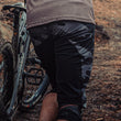 Load image into Gallery viewer, Odyssey Activewear Dark Camo Shield Shorts worn while mountain biking