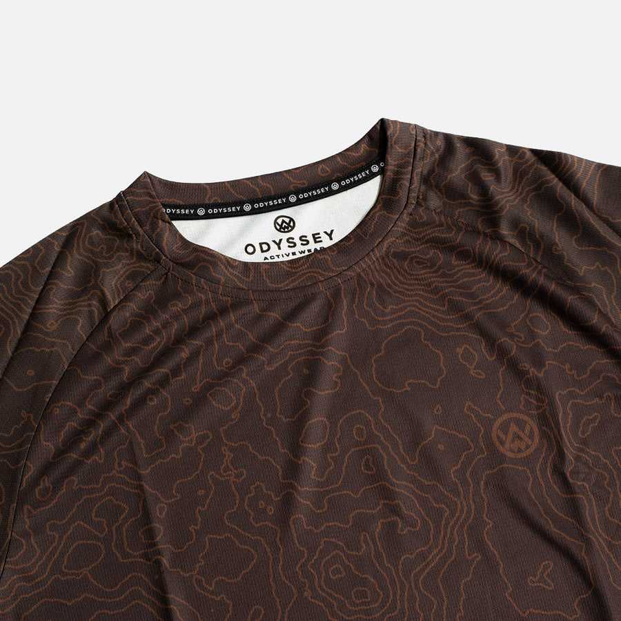Detail shot of the Odyssey Activewear Contour Earth T-shirt showing the breathable, quick-drying fabric and brown topographic map pattern