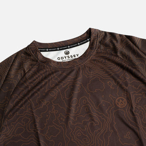 Detail shot of the Odyssey Activewear Contour Earth jersey showing the breathable, quick-drying fabric and brown topographic map pattern