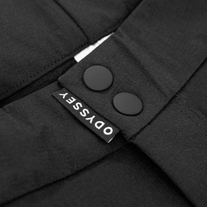 Detail shot of the snap fasteners and woven tag on the Odyssey Activewear Shield Trousers