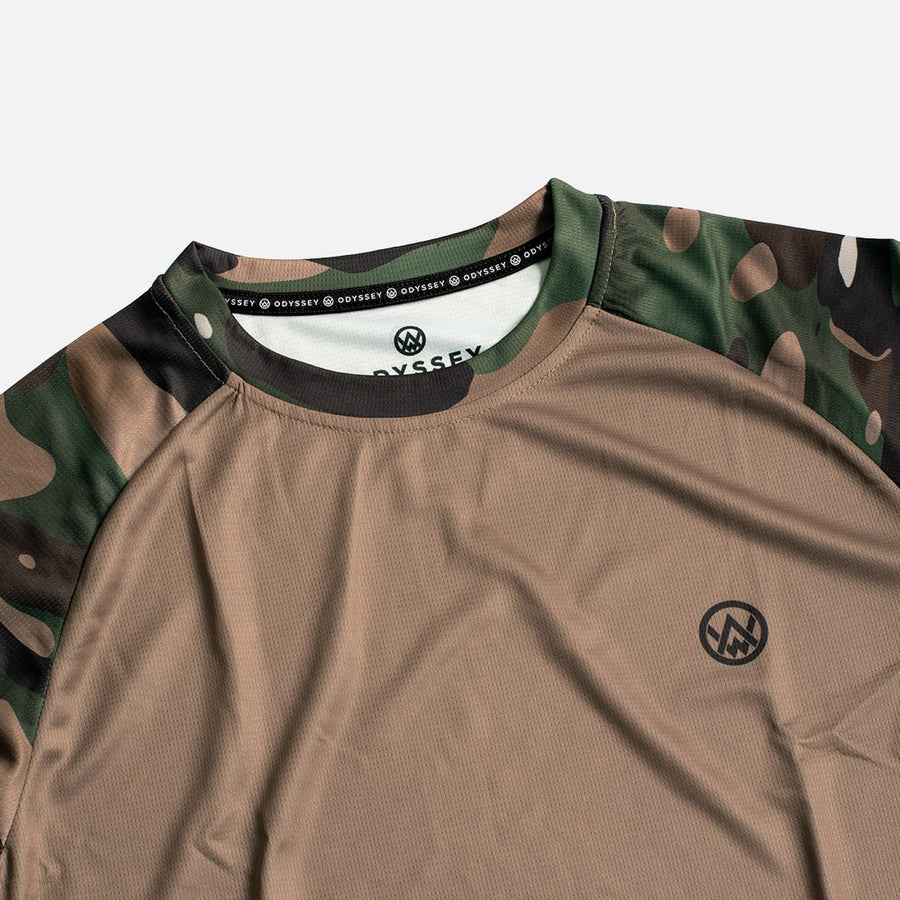Detail shot of the Odyssey Activewear Woodland Camo jersey showing the breathable, quick-drying fabric and green and brown camouflage colour scheme